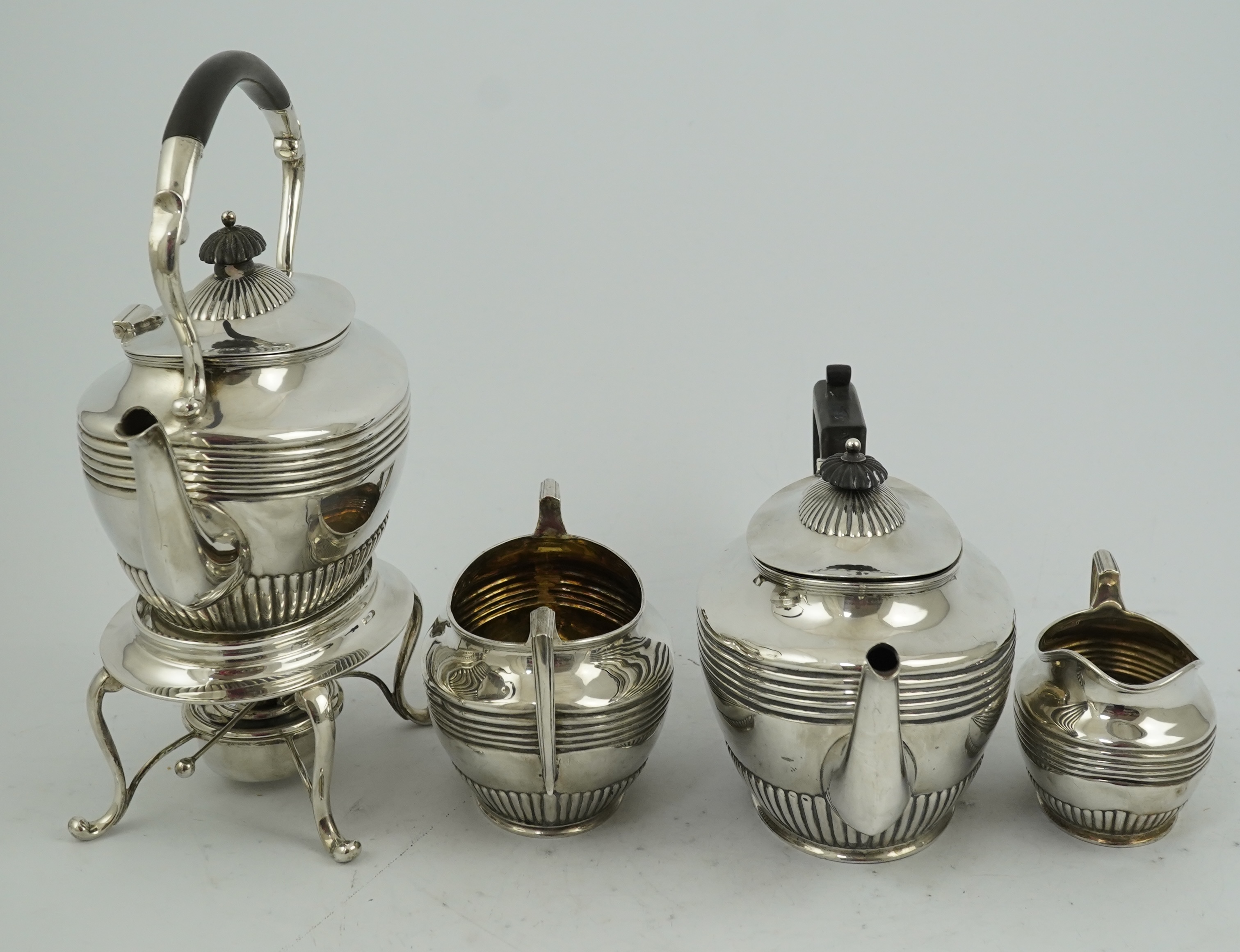 A matched Edwardian Scottish four piece demi fluted oval silver tea service by Wilson & Sharp